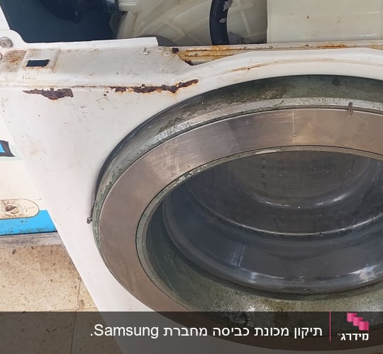 מכונת כביסה ישנה עם חלודה וחלקים חשופים